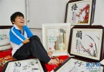 9月27日，任江敏在家中展示她用嘴绣制完成的十字绣作品。 - 妇女联合会