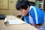 　9月27日，任江敏在家中用嘴咬笔练习写字。 - 妇女联合会