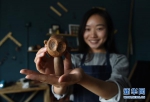 吴乐展示她设计制作的第一件木艺品“小猴子”（摄于5月7日）。 - 妇女联合会