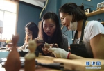 吴乐（右二）在木作体验课上指导顾客制作工艺木勺（摄于5月6日）。 - 妇女联合会