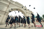 资料图：毕业生们齐齐在校门高呼“我们毕业了”。莫小布 摄 - 江苏音符
