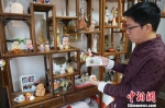 图为倪俊展示以“惠山泥人”为原型制作的充电宝。　孙权 摄 - 江苏新闻网