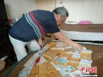 蔡国基正在家中整理韩昌鸿寄自台湾的信件。　钟升 摄 - 江苏新闻网