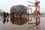 资料图：江苏泰州一家造船厂内，工人经过工地。　泱波　摄 - 江苏新闻网