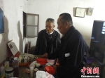 吴正权（右）在教黄发来老人使用居家养老服务热线电话。　于从文　摄 - 江苏新闻网