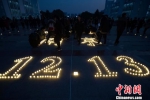 学生们在摆放“1213、80年”等字样蜡烛。　泱波　摄 - 江苏新闻网