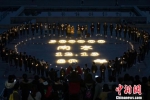 众多学生围着烛光默默哀悼，以寄哀思。　泱波 摄 - 江苏新闻网