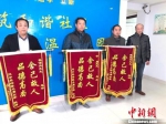 陈香怀代表全家人向热心救人的三名工人赠送锦旗。　顾名筛　摄 - 江苏新闻网