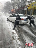 南京城管在雪中帮助市民。　赵渊 摄 - 江苏新闻网