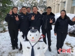 　　扫雪完成，金周(右二)和他的小伙伴们堆了警察雪人合影 唐娟 摄 - 江苏新闻网