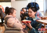 图为身穿古装的美女与用餐孩童互动。 - 江苏新闻网