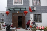65岁的王克标家门前不仅挂上了国旗，还挂上对喜庆的红灯笼。　于从文 摄 - 江苏新闻网