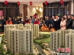 在南京河西南部一家热门楼盘，置业顾问用大喇叭向看房人进行讲解。　朱晓颖 摄 - 江苏新闻网