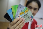 资料图：一位南京市民展示她所拥有的不同银行的银行卡。中新社记者 泱波 摄 - 江苏新闻网