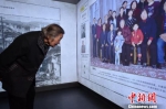 老人在仔细观看幸存者的全家福照片。　蔡美婷 摄 - 江苏新闻网
