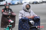 资料图：气温骤降，民众身穿冬衣出行。中新社记者 武俊杰 摄 - 江苏新闻网