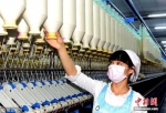 资料图：江苏纺织工人正在生产纱线。周晓明 摄 图片来源：视觉中国 - 江苏新闻网