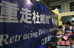 参与者们在活动背景板上签名。　泱波 摄 - 江苏新闻网