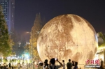 资料图：随着中秋佳节的临近，一轮“大月亮”亮相南京街头，吸引了大批市民前来驻足留影。中新社记者 泱波 摄 - 江苏新闻网