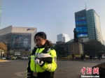 　在南京新街口的十字路口，交警脱帽默哀。　李珂 摄 - 江苏新闻网