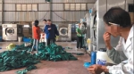 11月30日，丰源洗衣中心内大量的手术布草堆在地上等待洗涤，一名身穿蓝色衣服的工人用脚踩着布草。 新京报记者 尹亚飞 摄 - 新浪江苏