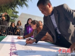 5日是清明节。清晨，南京大屠杀幸存者后代在“南京大屠杀幸存者后代传承记忆行动”卷轴上悉数落笔签名，以表达参与到南京大屠杀历史记忆传承行动中来。　朱晓颖　摄 - 江苏新闻网