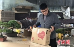 经过一天的忙碌，周王成将当天销售的盆景打包，交给快递公司。　刘林　摄 - 江苏新闻网