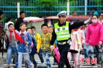 图为江苏宿迁民警护送小学生过马路。　江苏警方 供图 摄 - 江苏新闻网
