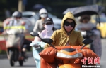 图为市民包裹严实“战高温”。　泱波 摄 - 江苏新闻网