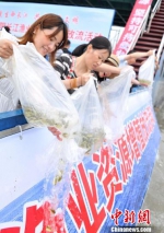 图为志愿者们将鱼苗倒入江中。　张岚 摄 - 江苏新闻网