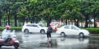 资料图：民众在雨中出行。翟李强 摄 - 江苏新闻网