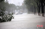8月10日，浙江温岭，一辆轿车在积水严重的道路上行驶。中新社发 金云国 摄 - 江苏新闻网