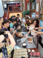 留学生和网红"大V”，把学习包锅贴的经历全程线上直播，让更多网友感受传统美食魅力。　刘阳 摄 - 江苏新闻网