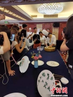 名厨现场展示中国传统大菜松鼠鳜鱼的做法，大家都忍不住拿起了手机拍摄。　刘阳 摄 - 江苏新闻网