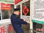 图为工作人员张贴宣传标语。　江苏省市场监管局供图　 - 江苏新闻网