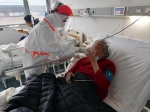 在武汉大学人民医院东院重症病房，上海医疗队护士喂87岁老先生喝粥。 中山医院供图 - 新浪江苏