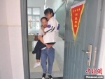 　　母亲背着陈雨欣走出教室。新区小学供图 - 新浪江苏
