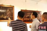 常州市委统战部副部长汤建忠带领学员们参观徐枫的红木浅刻作品。 徐悦 摄 - 江苏新闻网