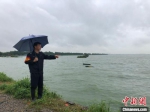 在太湖无锡贡湖沿线，巡查人员向记者介绍水位上涨的情况。　孙权　摄 - 江苏新闻网