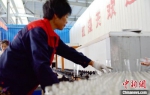 工人忙碌在玻璃瓶喷涂流水线上。　朱志庚 摄 - 江苏新闻网