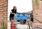 在安国镇张庄村，刚换掉手压井的村民杨巧荣欢喜地拧开水龙头。　朱志庚 摄 - 江苏新闻网