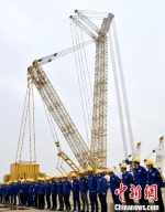 生产研发团队的工人师傅们在巨大的吊机下列队欢送第三台“国之重器”。　朱志庚 摄 - 江苏新闻网