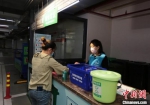 居民在督导员的指导下整理垃圾袋。　肖日东 摄 - 江苏新闻网