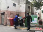 南京市实施垃圾强制分类首日，不少垃圾箱前都有督导员“站岗”。　南京市城管局供图 - 江苏新闻网