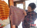 “毛衣奶奶”顾金珍在整理织好的毛衣。南通市崇川区委宣传部供图 - 江苏新闻网