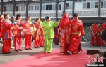新人们跨火盆、过马鞍等体验古代扬州盐商的婚礼仪式。　孟德龙 摄 - 江苏新闻网