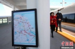 12月30日，盐通高铁开通运营。图为旅客从江苏铁路网宣传板前经过。　泱波 摄 - 江苏新闻网