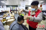 春节期间，志愿者理发师在南京某快递点为快递小哥免费理发。　泱波 摄 - 江苏新闻网