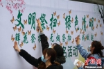 民众在“文明祭扫 绿色清明”背景板上贴上“蝴蝶”，表明自身将响应倡议。　泱波 摄 - 江苏新闻网