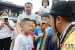 孩子们争相请“钟馗”在额头画“王”字，祈愿吉祥长寿。 - 江苏新闻网